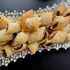 Paszteciki z pieczarkami, posypane sezamem, ułożone na ozdobnej paterze.