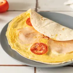 Pyszna tortilla z jajkiem, pomidorem i szynką, gotowa do zjedzenia.