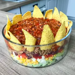 Warstwowa sałatka z nachosami, pełna smaków i kolorów. Idealna na imprezę!