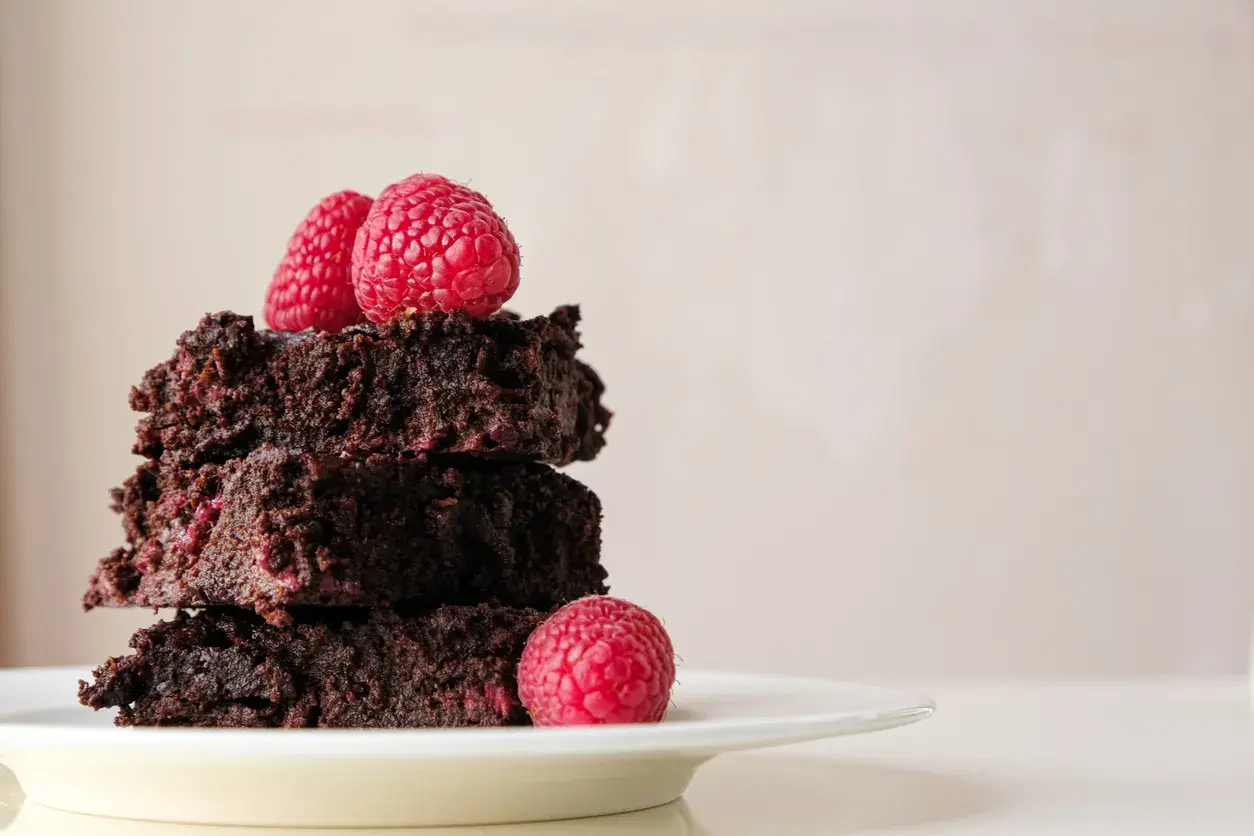 Stos pysznych brownie z malinami, idealne na deser.