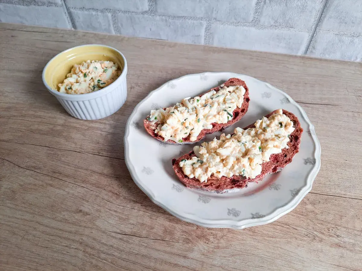 Pyszna pasta jajeczna ze szczypiorkiem na ciemnym pieczywie. Idealna na śniadanie lub przekąskę.