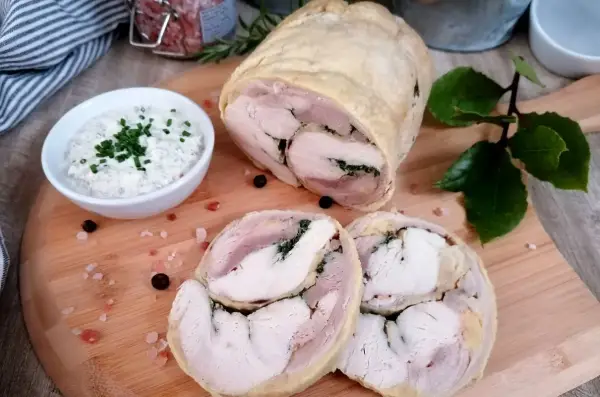 Galantyna z kurczaka, soczysta i aromatyczna, podana z kremowym sosem. Idealna na uroczysty obiad.